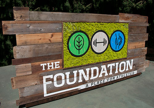 Elevate your local company's branding with a unique and eco-friendly custom sign made from reclaimed wood, preserved moss, and a hand-painted logo. Our visually striking design is sure to make a lasting impression on customers and enhance the rustic charm of your space by Urban Garden Studio Custom logo wrapped in preserved moss and incorporated into a reclaimed wood living wall by Urban Garden Studio