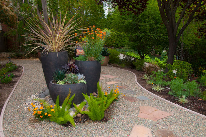 Elevate your outdoor living space with our expert custom garden design, featuring 3 tiered pots with drought-tolerant perennial plants and succulents, carefully arranged for maximum impact by Urban Garden Studio.