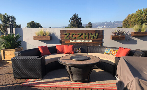 Experience the ultimate in sustainable design with our rooftop patio transformation, featuring reclaimed wood accents, custom brand sign with moss-covered letters, and rustic wall planters, expertly crafted for maximum impact by Urban Garden Studio.