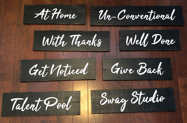 Stylish barn wood signage with hand-painted finish and custom branding for a company swag store by Urban Garden Studio Unique hand-painted barn wood signage for a company swag store with custom branding and design by Urban Garden Studio