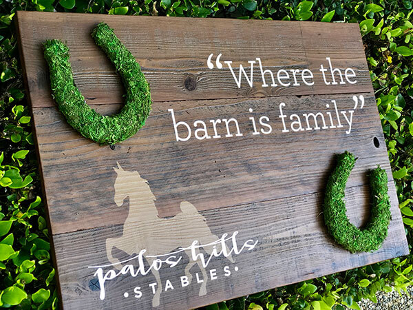 Eye-catching custom signage with reclaimed wood design and moss-covered logo for sustainable branding by Urban Garden Studio