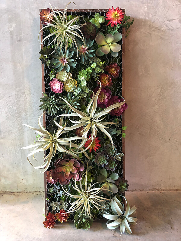 Beautiful succulent wall garden filled with faux succulents, air plants, preserved moss and framed out in rustic wood. Creating a vertical succulent garden.