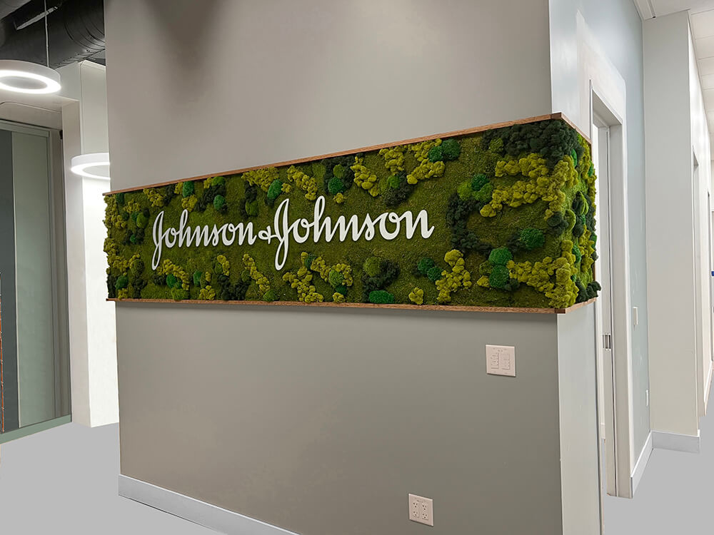 Vertical garden created with a beautiful wrapping moss wall with logo for corporate office by urban garden studio