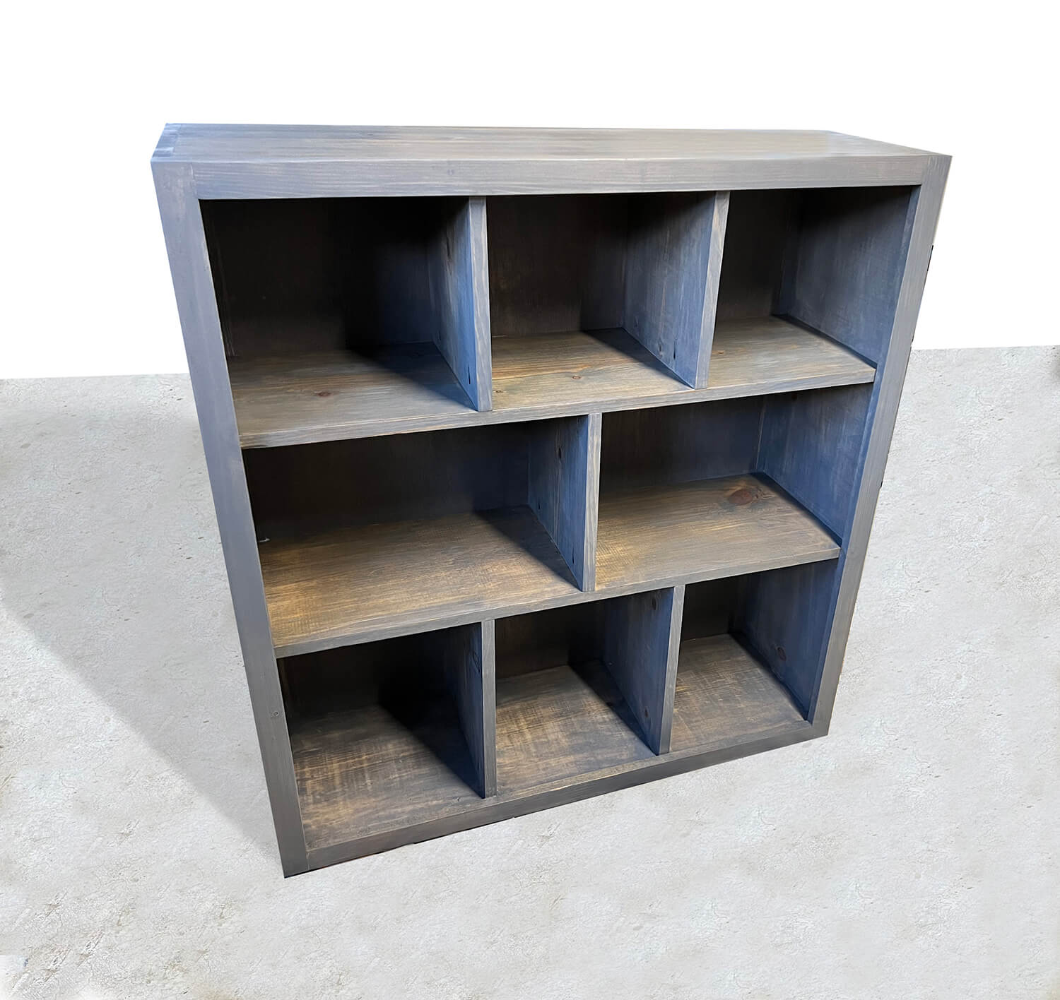 A handcrafted custom wooden bookshelf with a classic gray stain finish, featuring three shelves for you to fill with books and decorative items. 