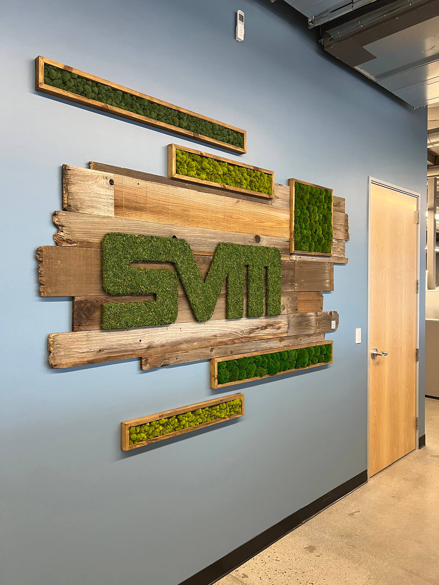 Eco-friendly brand moss signage featuring reclaimed wood, custom logo wrapped in preserved moss, making a visually striking and unique statement for your brand by Urban Garden Studio.